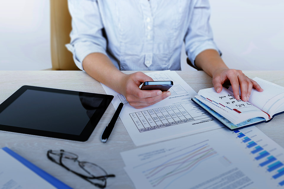 Woman at a desk looking over papers.