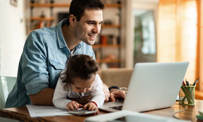 hombre que trabaja en una computadora en casa con su hijo