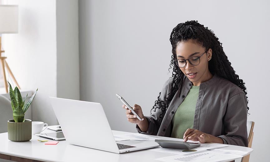 a female employee calculating her 401(k) balance to plan for retirement