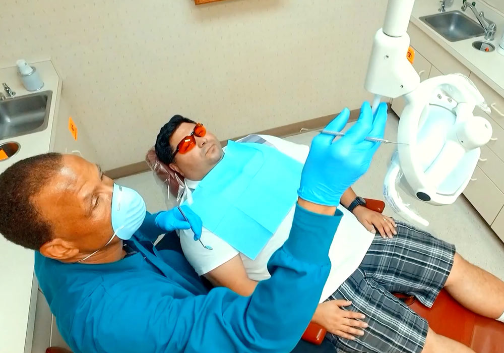 El propietario de un consultorio odontológico trabaja con un paciente durante una revisión de rutina. 