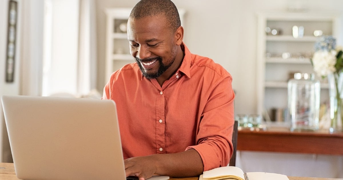 Man working on laptop computer at desk.
