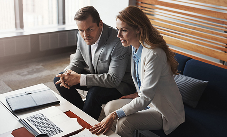 two executives reviewing a work on a laptop