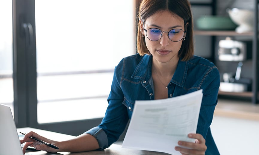 woman looking at her taxes and working in a laptop