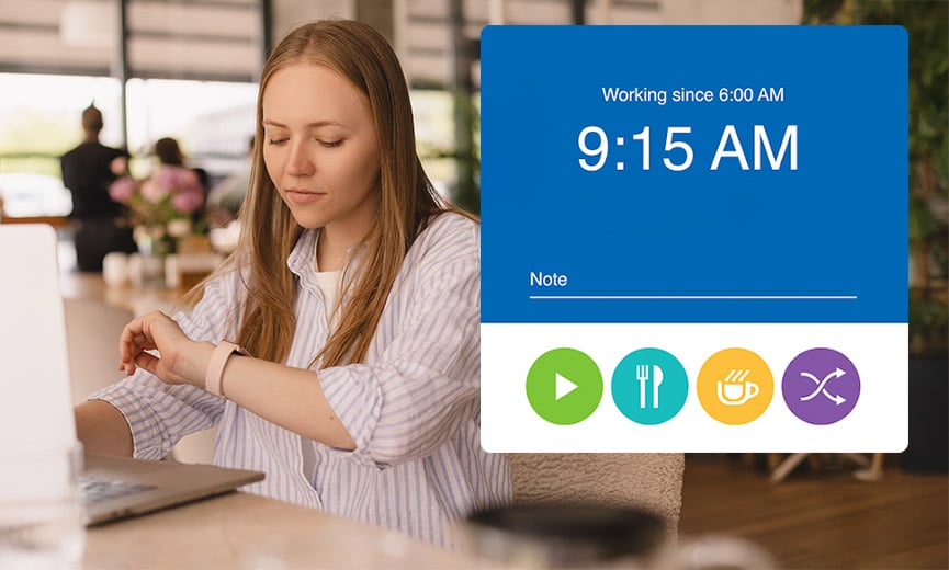 Woman working at a desk in a office checking an app on her watch