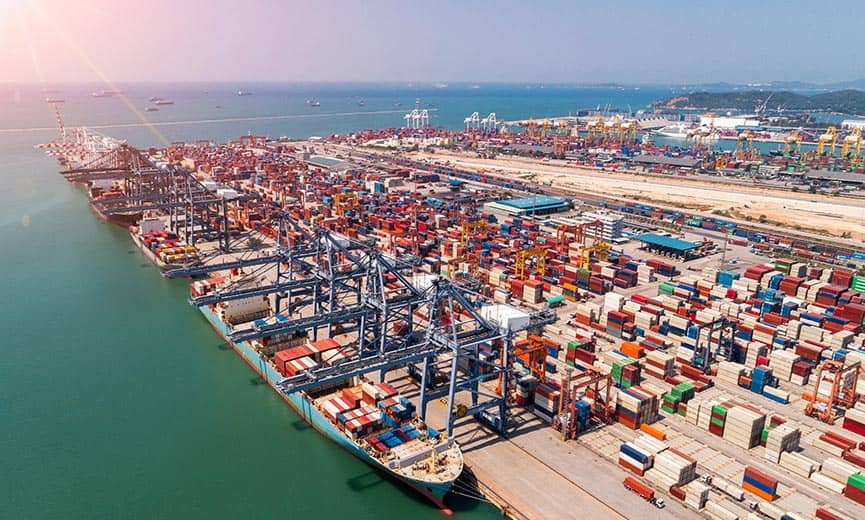 A busy port with shipping containers and cranes, representing international trade influenced by tariff