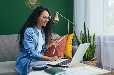 woman small business owner comparing insurance plans on a laptop in her home