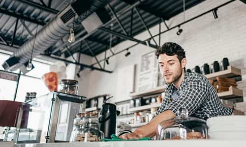 Hombre trabajando en el mostrador de una cafetería