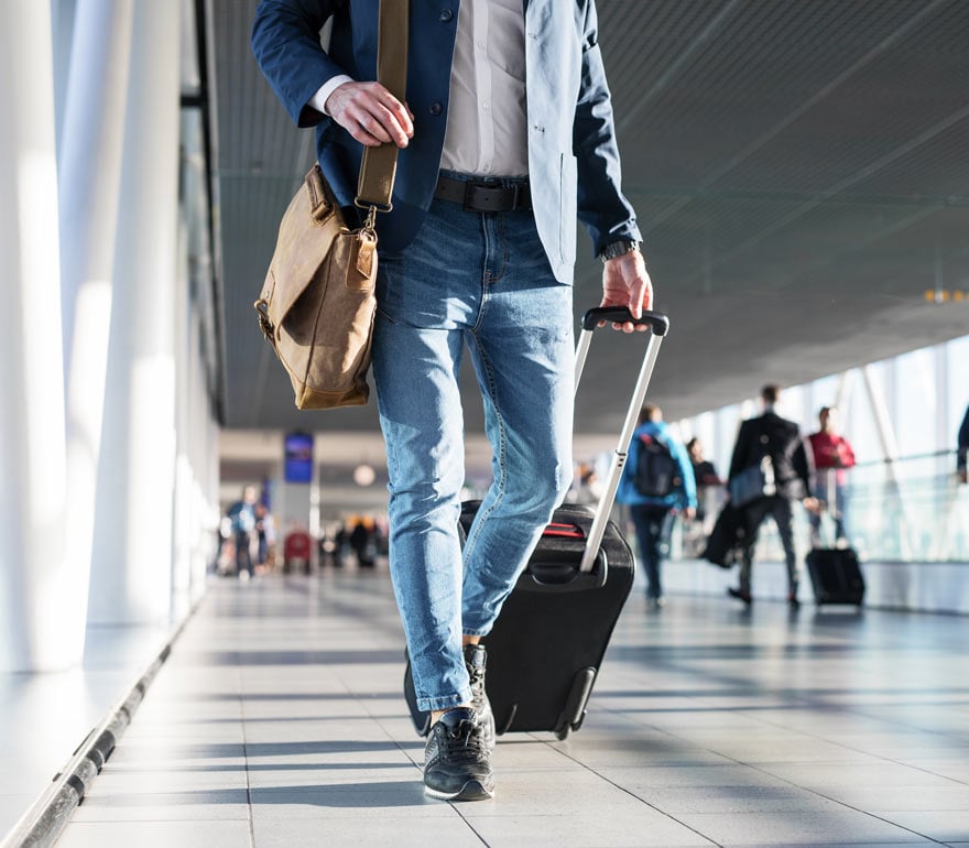 man walking through the airport with his luggage