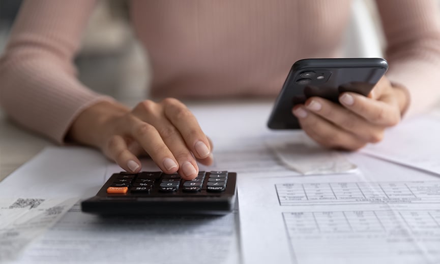 Mujer que hace cálculos sobre cuál cuenta de ahorros para la salud es la mejor