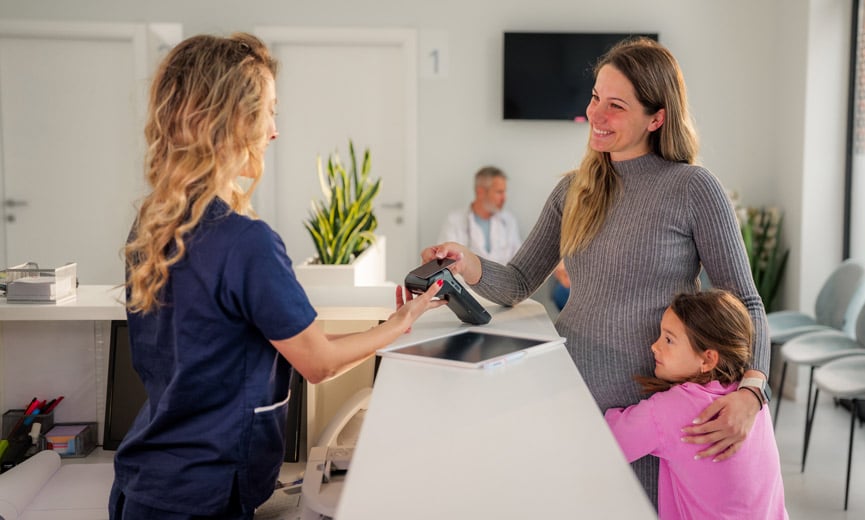 Mother paying for child using FSA at doctor's office