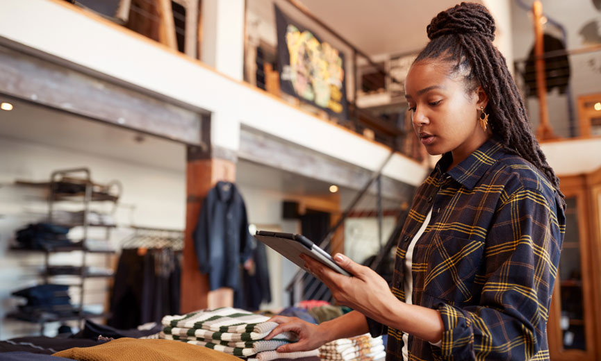 Retail worker checking Ipad on the shoowroom floor