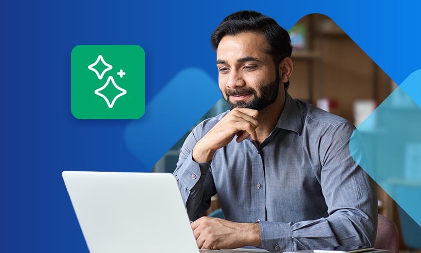 A person works at a laptop in a professional setting with a green sparkle icon displayed beside them.