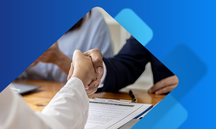 Interview candidate shaking hands after reviewing paperwork