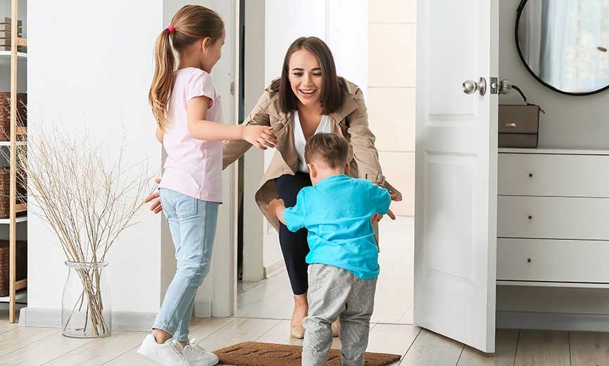 two happy children greeting their mother at the door after she finishes her four-day workweek