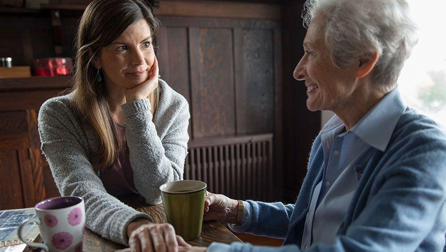A woman visits with an elderly family member.