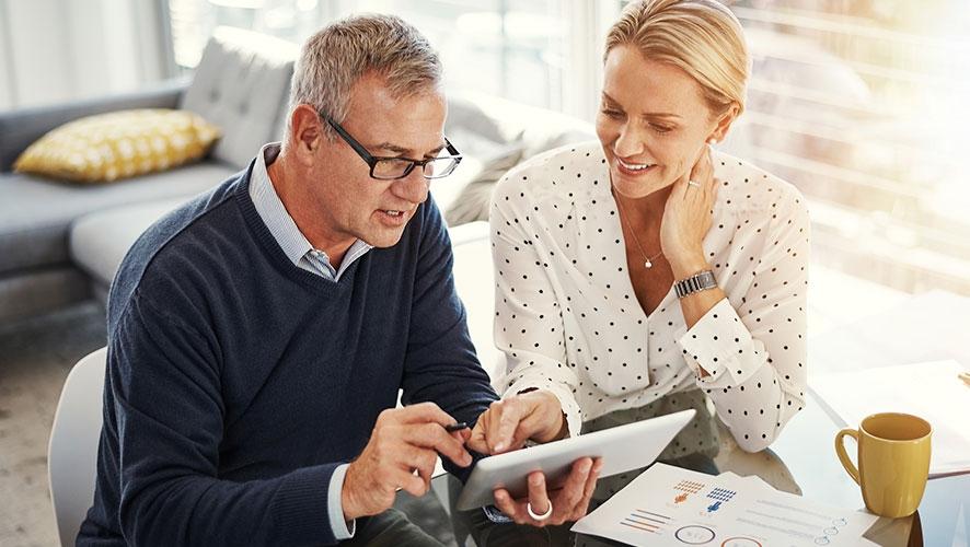 Un hombre y una mujer trabajan con papeleo para planificar su estrategia de ahorro para la jubilación.