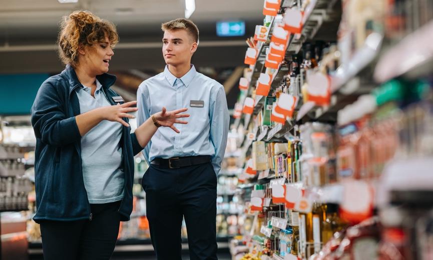 Full-time employee training a part-time employee in a grocery store