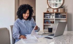 a small business owner processing payroll on her laptop