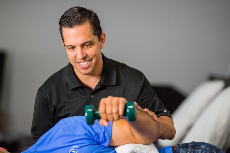 Andy del Rio ayuda a un cliente con un ejercicio para la mano