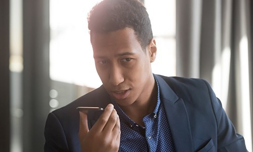 Man talking to mobile phone to run payroll with Paychex Voice Assist