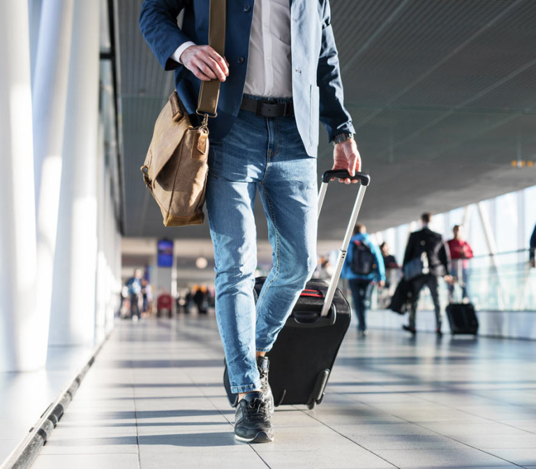 man walking through the airport with his luggage