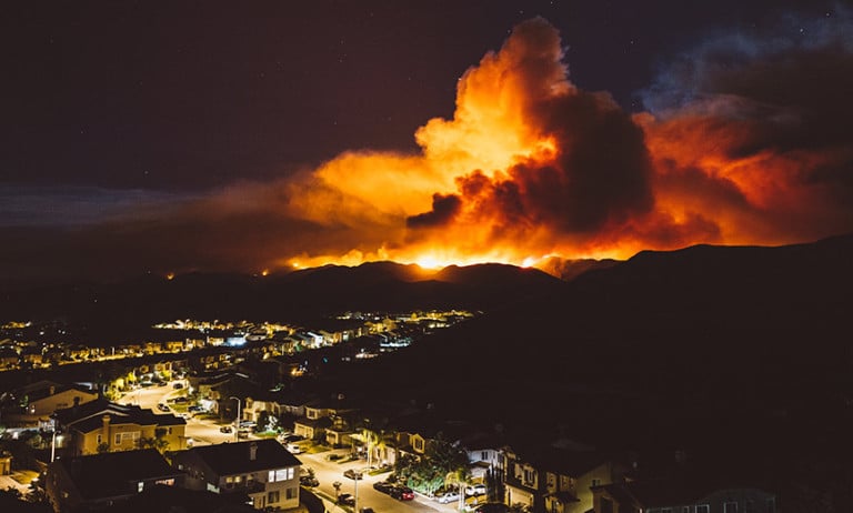 Wildfire rages near a community of homes and businesses.