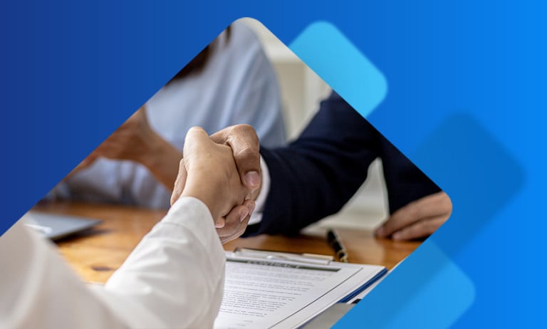 Interview candidate shaking hands after reviewing paperwork