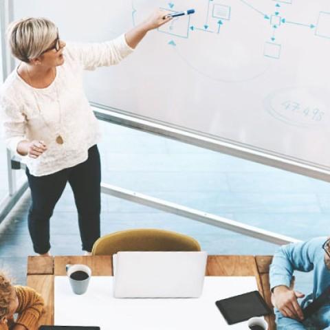 employer pointing to a whiteboard going over their long term strategic benefits plan