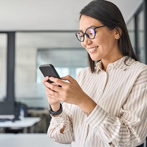 women checking her benefits on her cellphone and smiling 