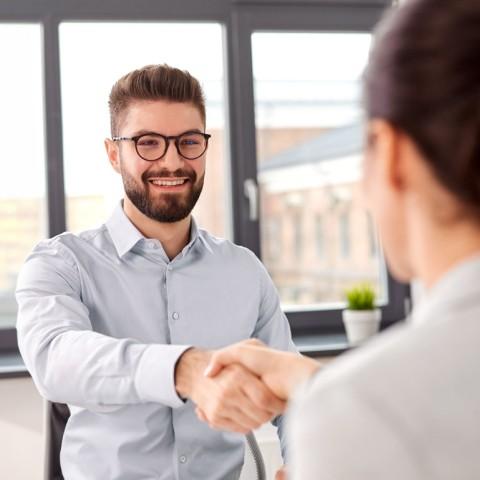 A job applicant shaking hands with the hiring manager 