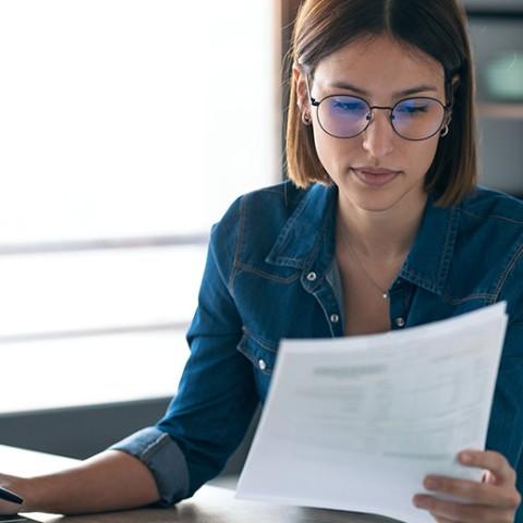woman looking at her taxes and working in a laptop