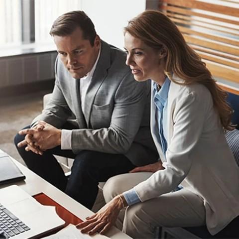 two executives reviewing a work on a laptop