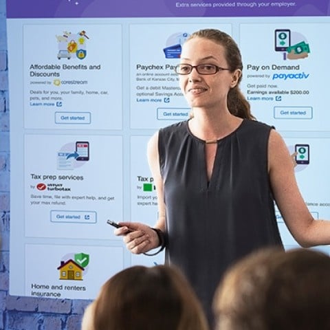 woman talking to an audience with the paychex benefits image as a background