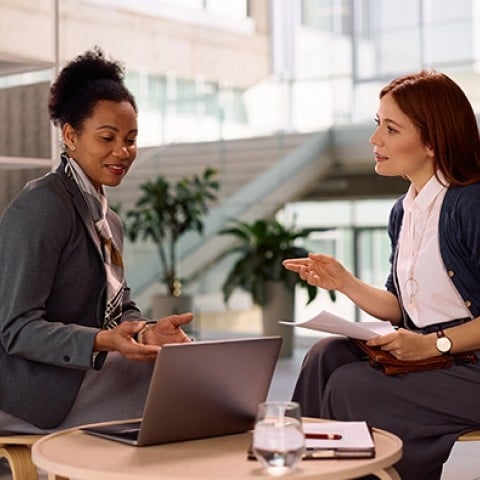 two executive women in a meeting with a laptop