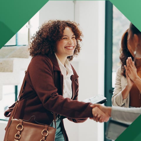 Woman shaking hands with new coworkers