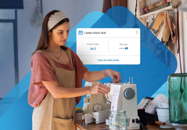 A self-employed person working, with payroll information behind her