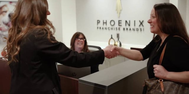 2 women shake hands at offices of Phoenix Brands