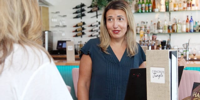 blond haired woman assists customer in restuarant