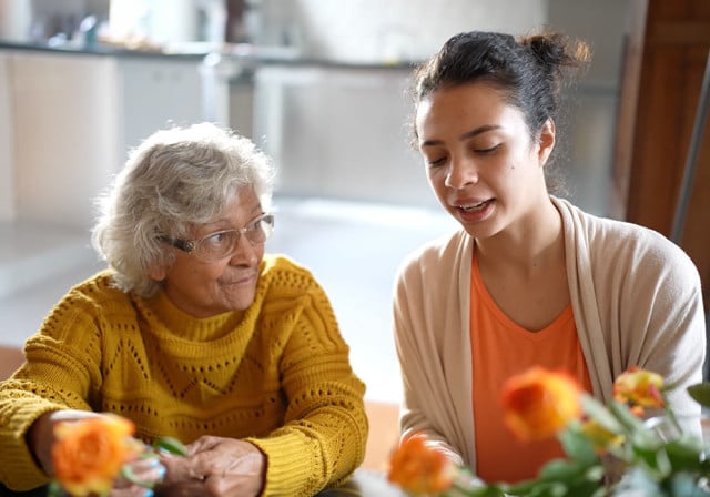 An employee works with a resident of a senior living community.