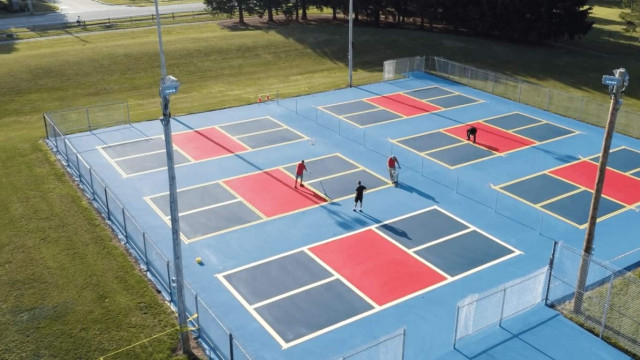 Employees of Super Seal Sealcoating Company put the finishing touches on brand-new pickle ball courts.