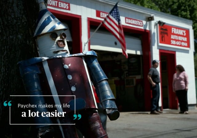 Tin Man made out of oil can scraps at left of car repair shop