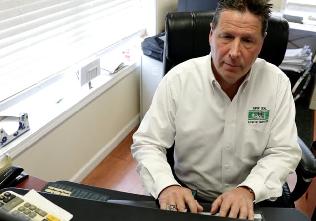 hombre con camisa blanca escribe en el teclado de la computadora
