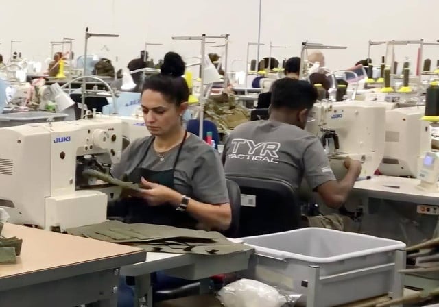 trabajadores en máquinas de coser en la planta de producción