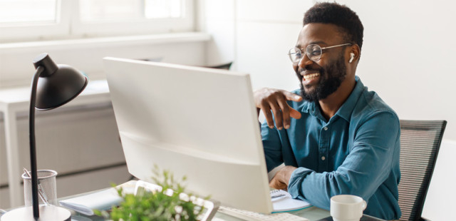 a smiling man working in his office