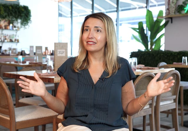 blond haired restaurant manager spreads hands apart to show room for growth