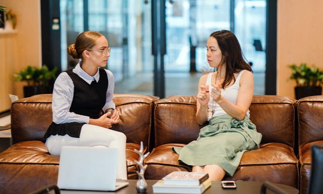 two coworkers talking on a coach