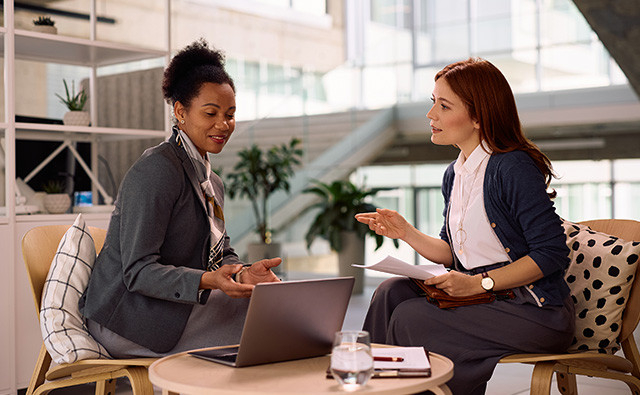 two executive women in a meeting with a laptop