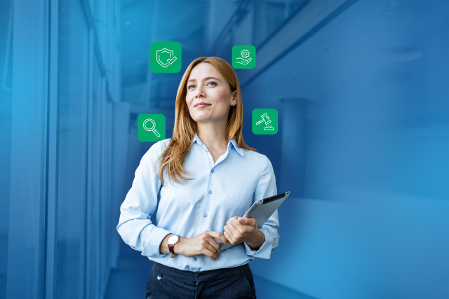 women hold a tablet standing against a blue background with digital icons around her