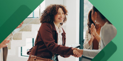 Woman shaking hands with new coworkers