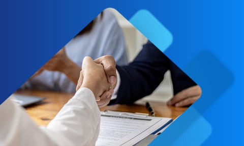 Interview candidate shaking hands after reviewing paperwork